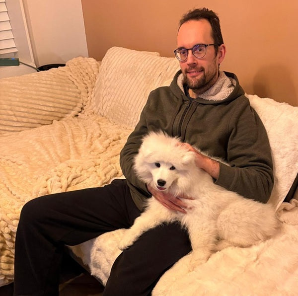 Oprichter van Senji met zijn hond Senji als puppy op de bank.